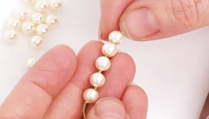 sistemare una collana di perle