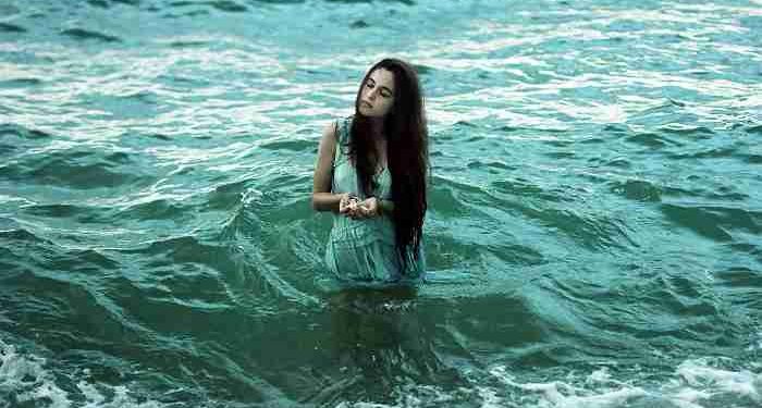 giovane ragazza cammina in mare