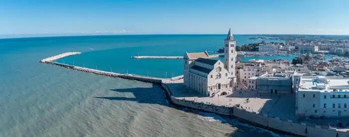Infografica di Trani con itinerari dalla stazione ferroviaria alle spiagge libere, agli stabilimenti balneari di Colonna e ai principali monumenti.